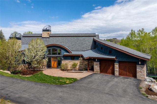 1115 Steamboat Blvd, Steamboat Springs, CO 80487 - contemporary home featuring a garage, stone siding, asphalt driveway, and a standing seam roof