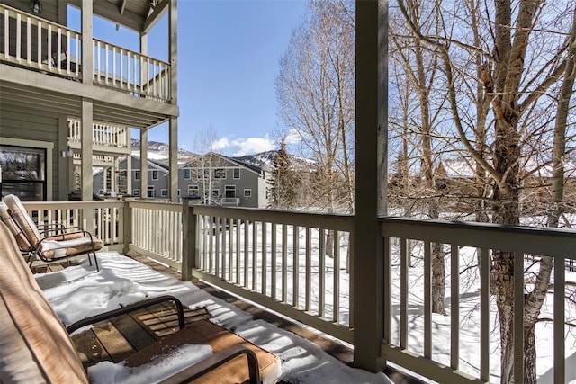 snow covered back of property with a residential view