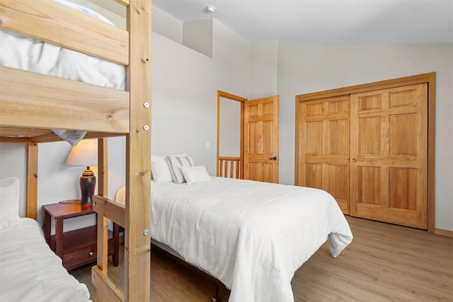 bedroom featuring lofted ceiling and light wood-style floors