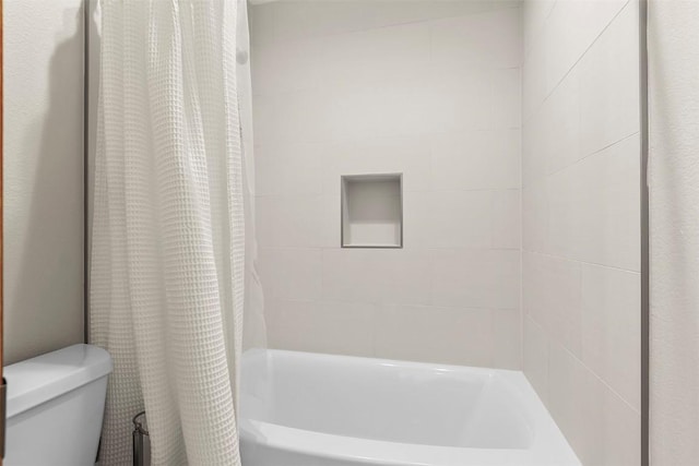 full bath featuring toilet and shower / bath combo with shower curtain