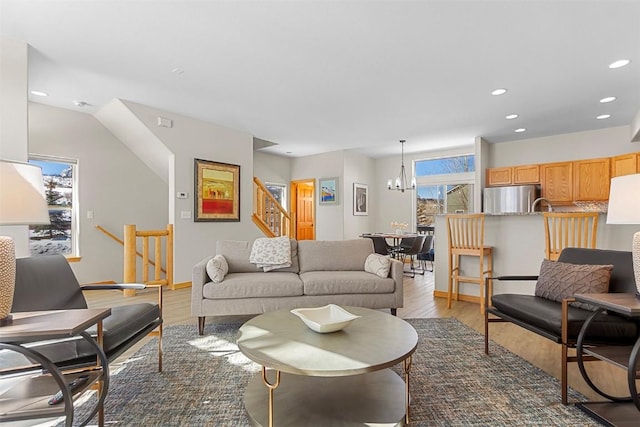 living room with stairs, a notable chandelier, recessed lighting, and light wood-type flooring