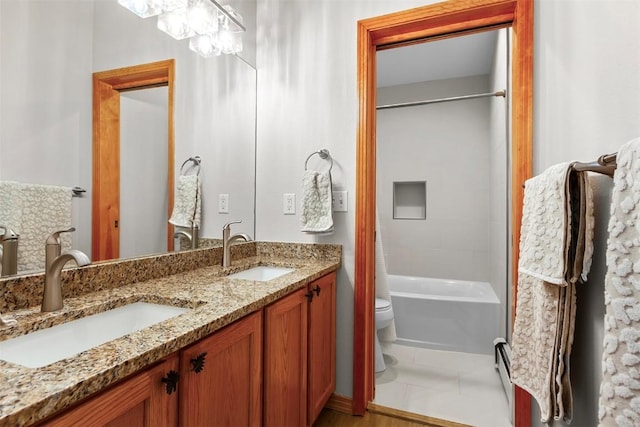 bathroom with double vanity, toilet, shower / washtub combination, and a sink