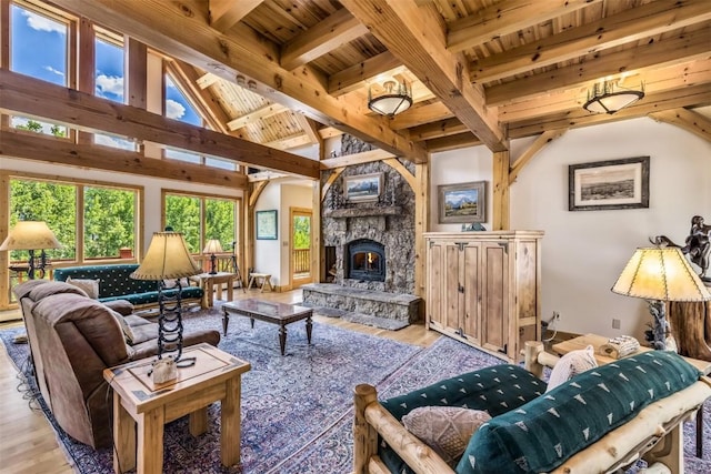 living room featuring beam ceiling, a fireplace, wooden ceiling, and light wood-type flooring