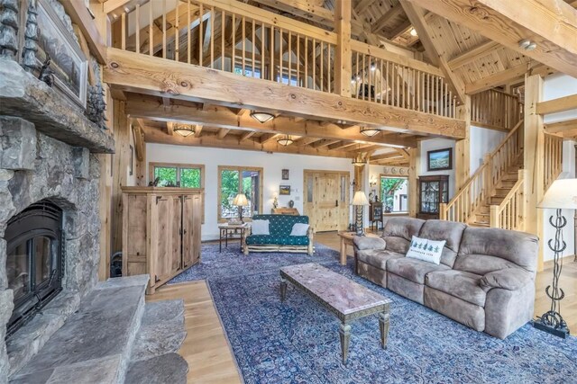 living room with beamed ceiling, wood-type flooring, high vaulted ceiling, and wood ceiling