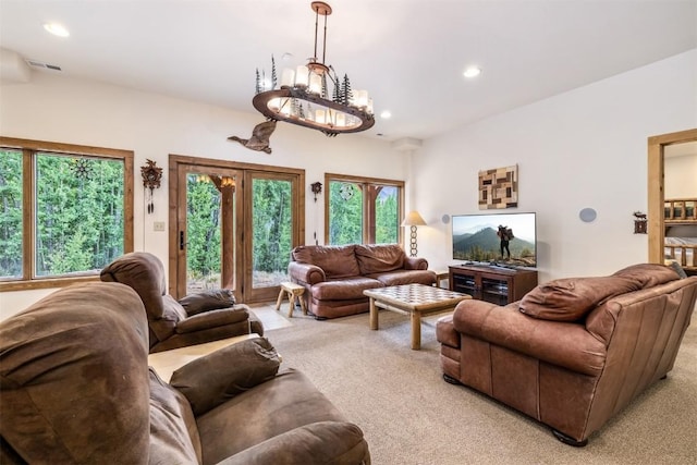 living room with light carpet and a notable chandelier