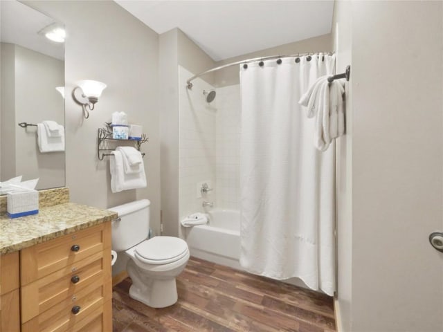 full bath with shower / bath combo, wood finished floors, toilet, and vanity