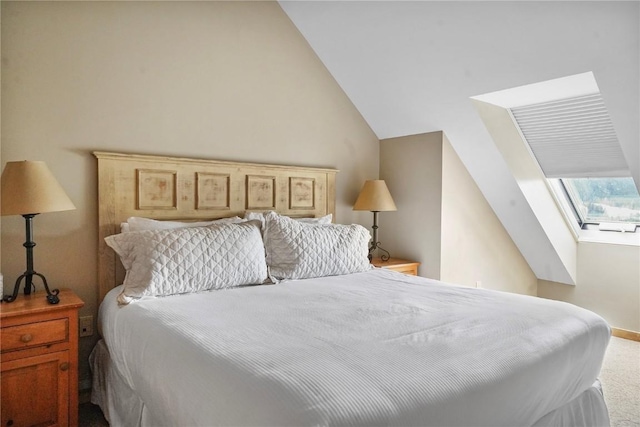 bedroom featuring baseboards, carpet flooring, and vaulted ceiling with skylight