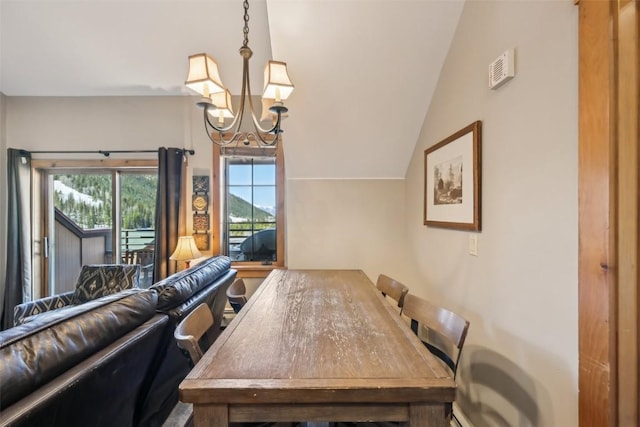 dining room with a notable chandelier and lofted ceiling