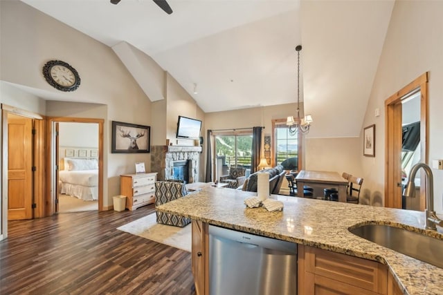 kitchen featuring a sink, a fireplace, vaulted ceiling, dishwasher, and open floor plan