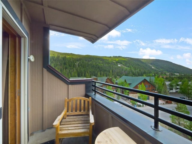 balcony featuring a mountain view and a view of trees