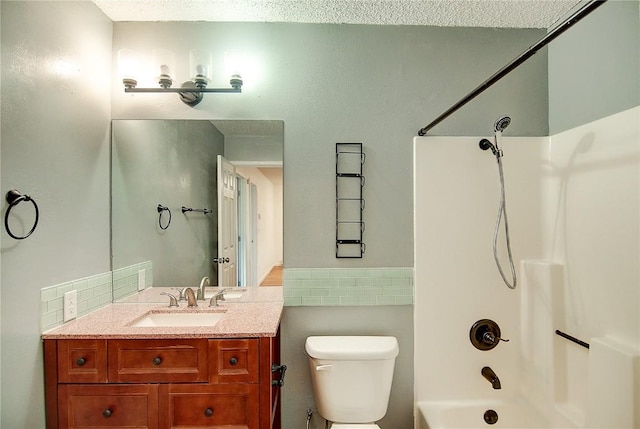 bathroom featuring shower / bathing tub combination, tile walls, toilet, and vanity