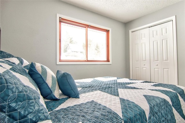 bedroom with a textured ceiling and a closet