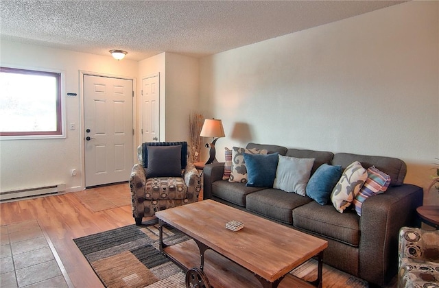 living room with light wood finished floors, a textured ceiling, and a baseboard radiator