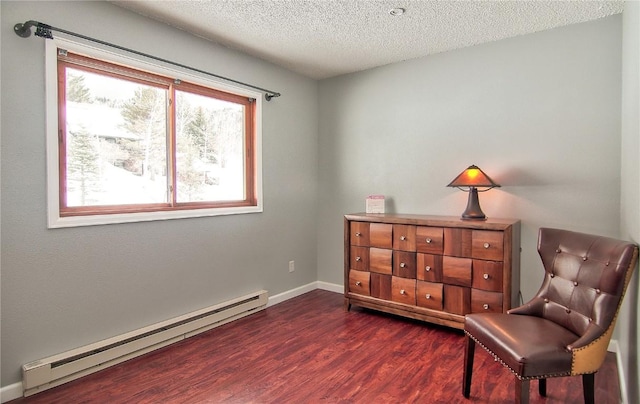 sitting room with a baseboard radiator, a wealth of natural light, a textured ceiling, and dark wood-style floors