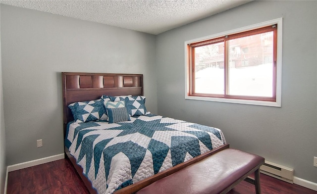 bedroom with baseboard heating, baseboards, and wood finished floors