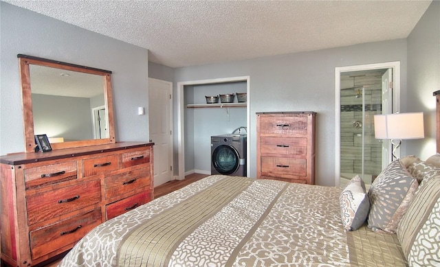bedroom with wood finished floors, connected bathroom, a closet, a textured ceiling, and washer / clothes dryer