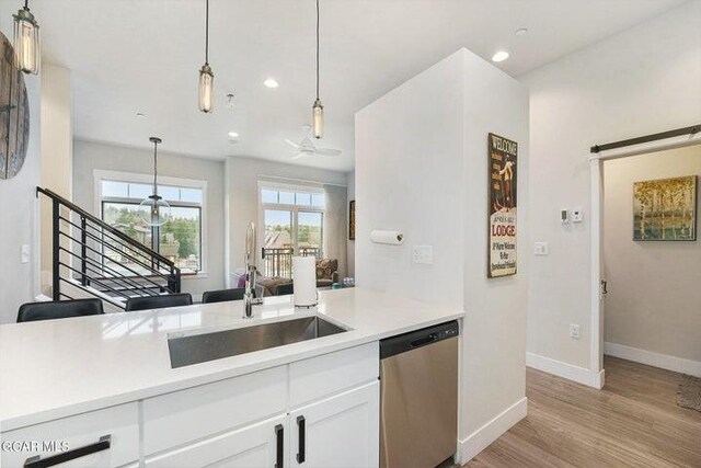 78311 US Highway 40 Unit 6, Winter Park, CO 80482 - kitchen with stainless steel dishwasher, baseboards, light wood-style floors, white cabinetry, and decorative light fixtures