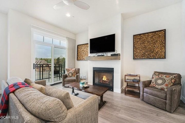 78311 US Highway 40 Unit 6, Winter Park, CO 80482 - living area featuring baseboards, wood finished floors, a lit fireplace, and ceiling fan