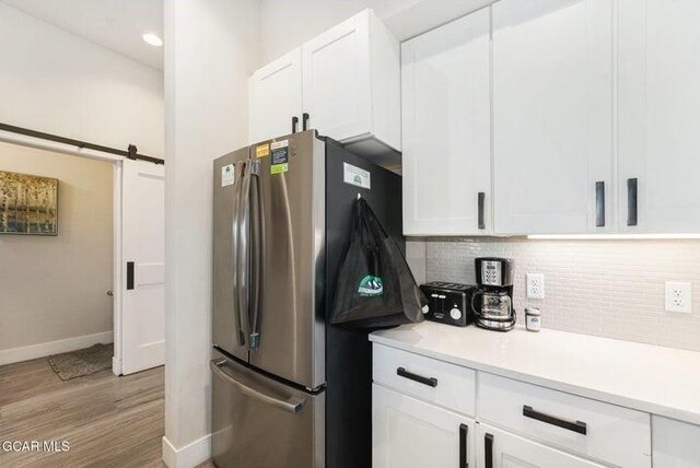 78311 US Highway 40 Unit 6, Winter Park, CO 80482 - kitchen with white cabinets, freestanding refrigerator, baseboards, decorative backsplash, and light wood-style flooring