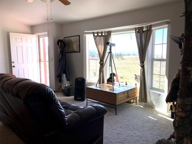 carpeted living room with a ceiling fan