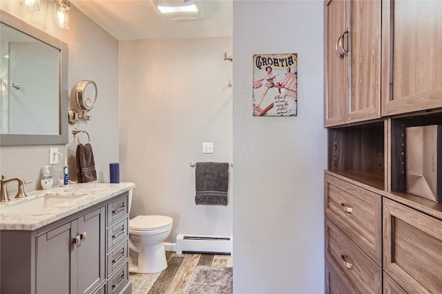 1437 Morgan Ct Unit 1437, Steamboat Springs, CO 80487 - bathroom featuring wood finished floors, toilet, vanity, a baseboard heating unit, and baseboards