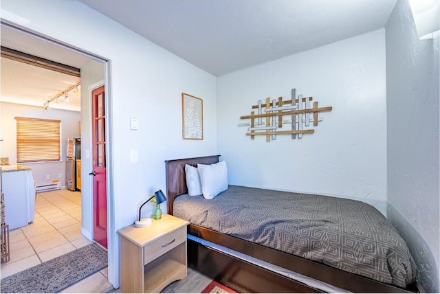 bedroom featuring a baseboard radiator, track lighting, and light tile patterned floors