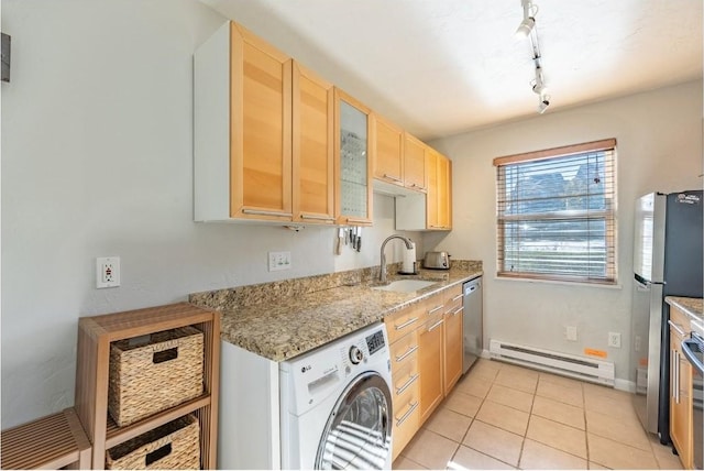 kitchen with light brown cabinets, a sink, a baseboard heating unit, stainless steel appliances, and washer / clothes dryer