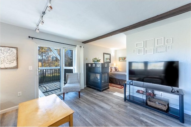 sitting room with beamed ceiling, track lighting, wood finished floors, and baseboards