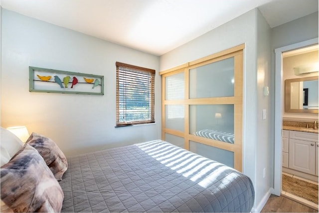 bedroom with wood finished floors and a sink