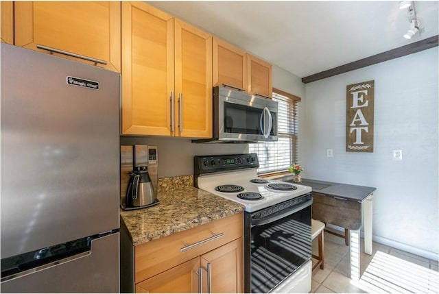 kitchen with light brown cabinetry, track lighting, light tile patterned flooring, light stone countertops, and appliances with stainless steel finishes