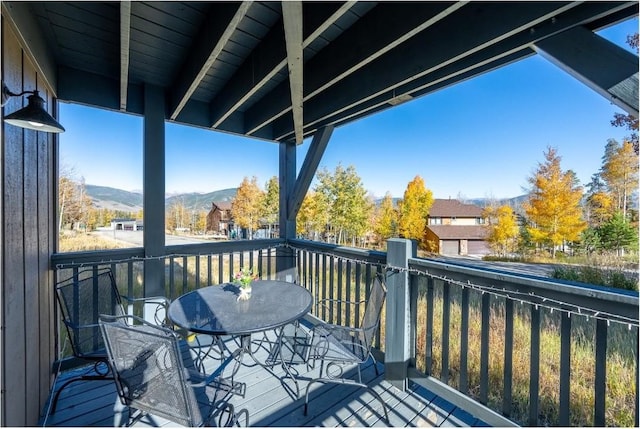 wooden deck featuring outdoor dining space and a mountain view