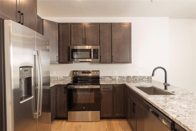 35 Argentine Ct Unit 303, Keystone, CO 80435 - kitchen featuring stainless steel appliances, light wood-type flooring, dark brown cabinets, and light stone counters