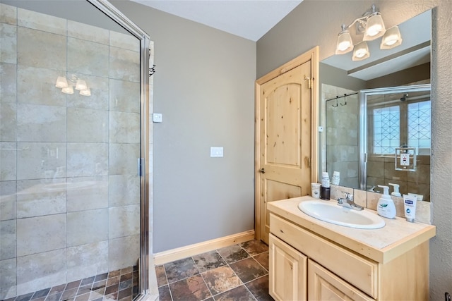 full bathroom with baseboards, vanity, and a stall shower