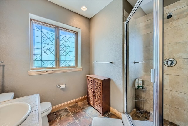 full bath with baseboards, toilet, vanity, and a stall shower