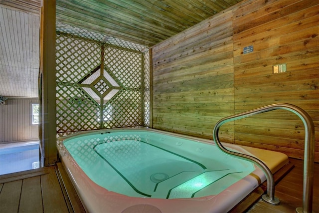 interior space with wood ceiling, wood walls, and a hot tub