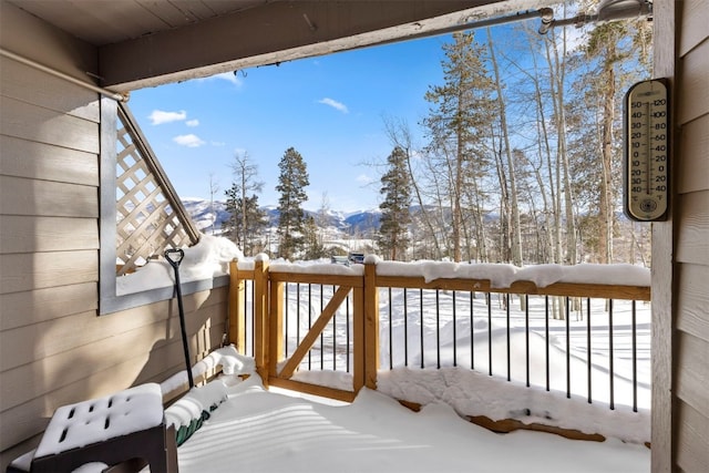 snow covered deck with a mountain view