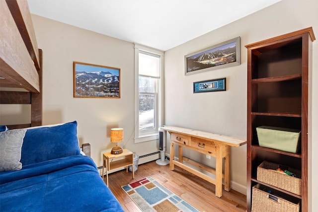 bedroom with a baseboard radiator and wood finished floors