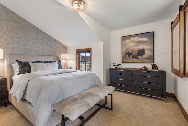 317 Granite St Unit 5, Frisco, CO 80443 - bedroom with a barn door, light colored carpet, wallpapered walls, baseboards, and an accent wall