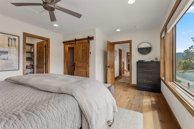 317 Granite St Unit 5, Frisco, CO 80443 - bedroom with light wood-type flooring, recessed lighting, a barn door, a ceiling fan, and baseboards
