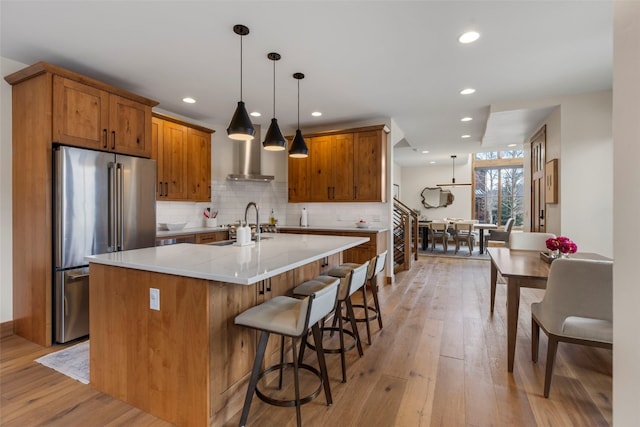 317 Granite St Unit 5, Frisco, CO 80443 - kitchen featuring high end refrigerator, brown cabinetry, backsplash, light wood-style floors, and recessed lighting