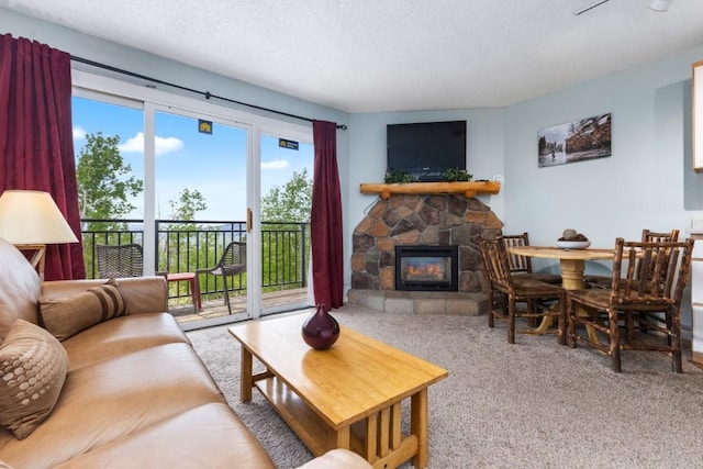 2883 Burgess Creek Rd Unit 203, Steamboat Springs, CO 80487 - living room with carpet floors, a fireplace, and a textured ceiling