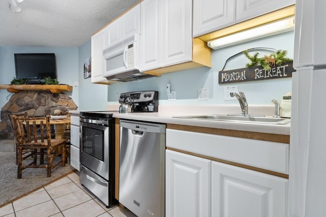 2883 Burgess Creek Rd Unit 203, Steamboat Springs, CO 80487 - kitchen featuring appliances with stainless steel finishes, a sink, white cabinetry, light tile patterned floors, and open floor plan