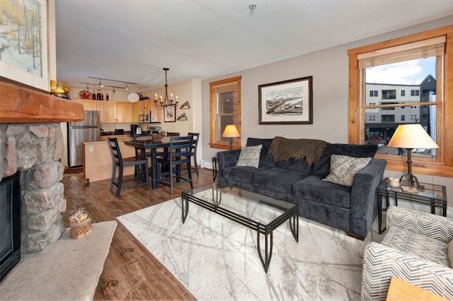 100 Dercum Sq Unit 8342, Keystone, CO 80435 - living room with a baseboard heating unit, dark wood finished floors, a notable chandelier, a fireplace, and rail lighting