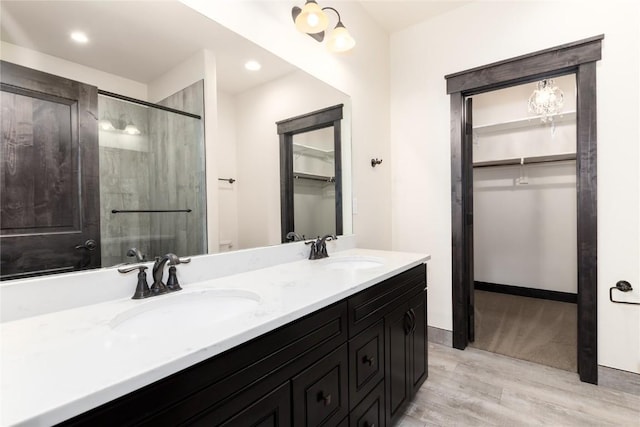 750 Independence Rd Unit 2C, Keystone, CO 80435 - bathroom with wood finished floors, a walk in closet, double vanity, a shower with shower door, and recessed lighting
