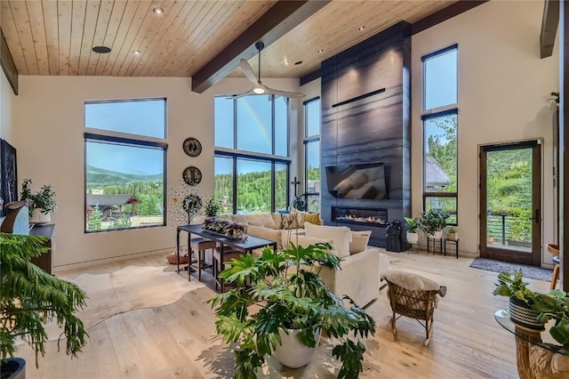 313 Raven Golf Ln, Silverthorne, CO 80498 - living area with wood finished floors, a large fireplace, plenty of natural light, a wood ceiling with exposed beams, and a towering ceiling