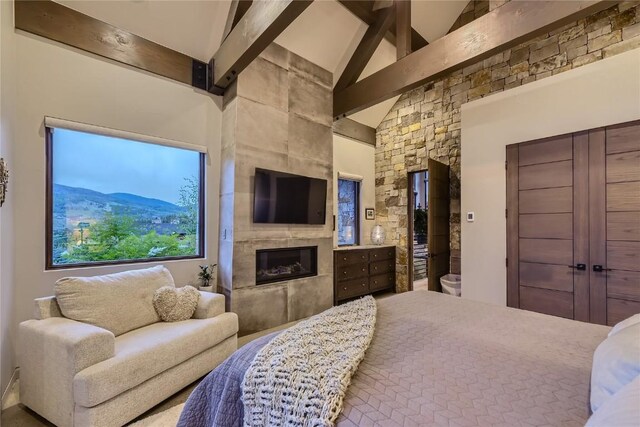 313 Raven Golf Ln, Silverthorne, CO 80498 - bedroom featuring beam ceiling, a tiled fireplace, and high vaulted ceiling