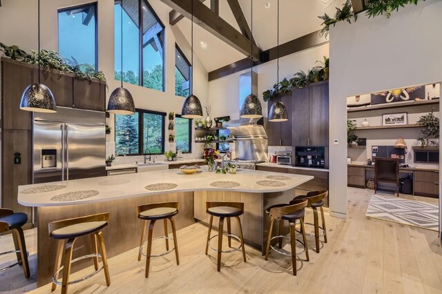 313 Raven Golf Ln, Silverthorne, CO 80498 - kitchen with stainless steel appliances, high vaulted ceiling, modern cabinets, light countertops, and a kitchen bar