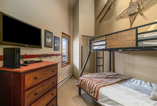 2800 Village Dr Unit 1302, Steamboat Springs, CO 80487 - bedroom with baseboard heating, light colored carpet, baseboards, and a high ceiling
