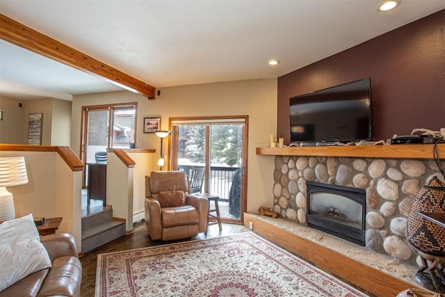 living area featuring a stone fireplace, wood finished floors, beam ceiling, and recessed lighting