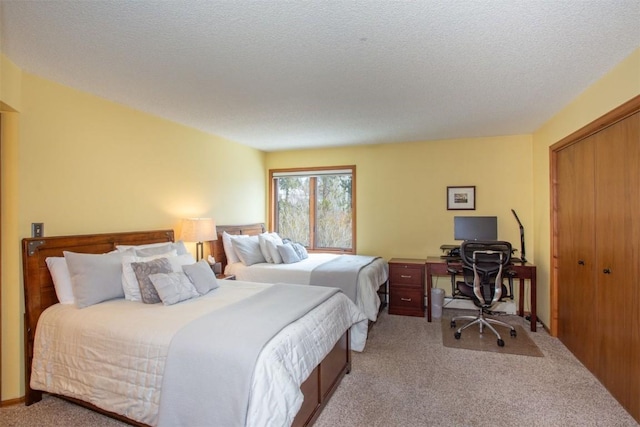 bedroom featuring a textured ceiling, a closet, and light colored carpet